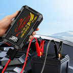 Car jump starter being held over a car battery with a scenic background