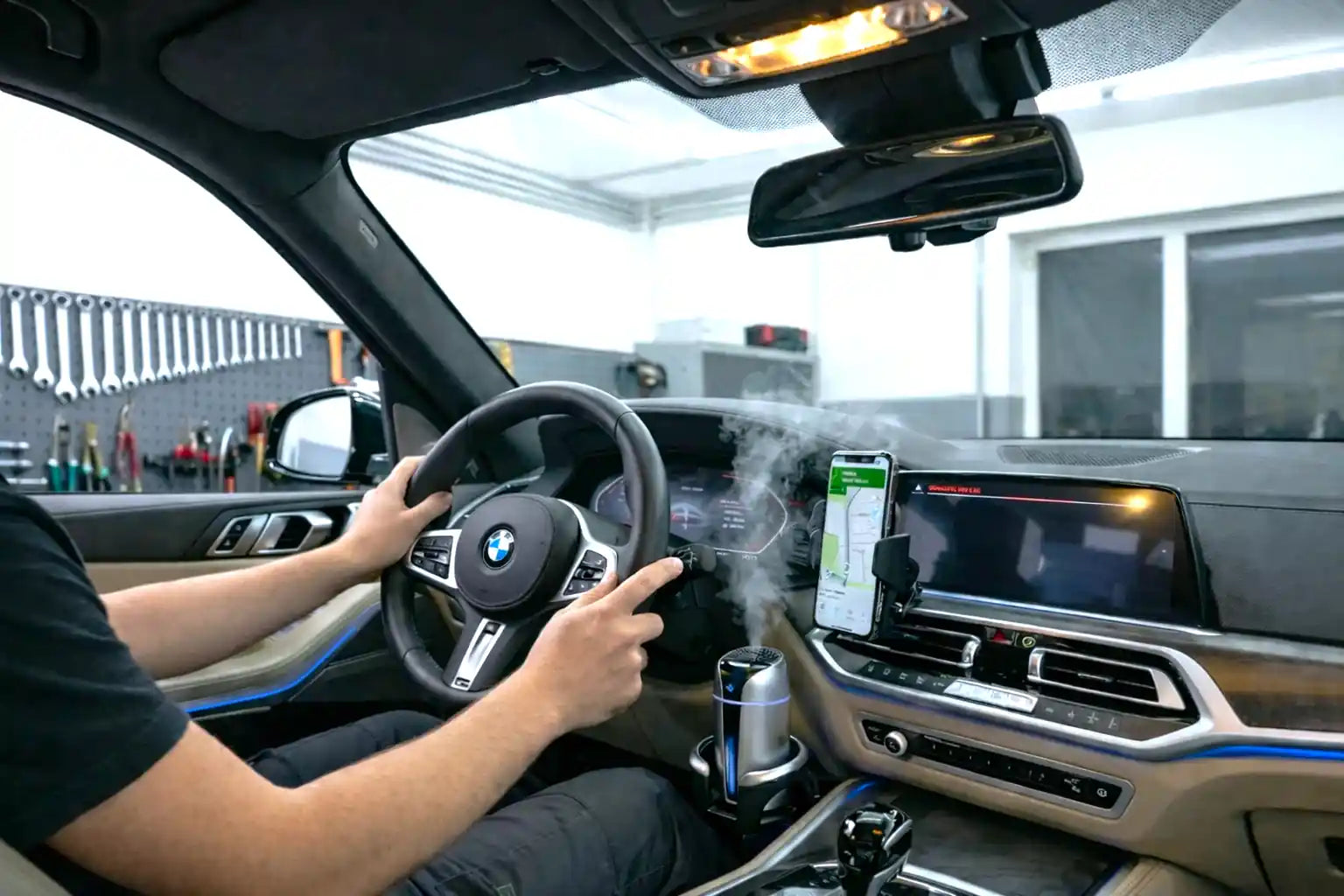 Person driving a car with a focus on the steering wheel and dashboard.