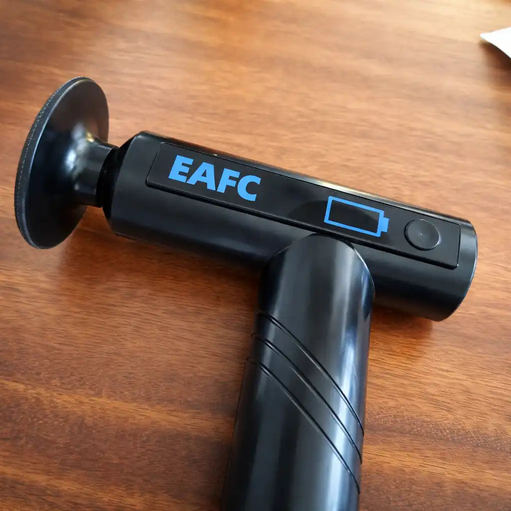 Black handheld device with 'EAFC' branding on a wooden surface