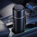 Black thermos in a car cup holder with a blurred background