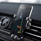 Phone mounted on a car holder with navigation app displayed, inside a vehicle.