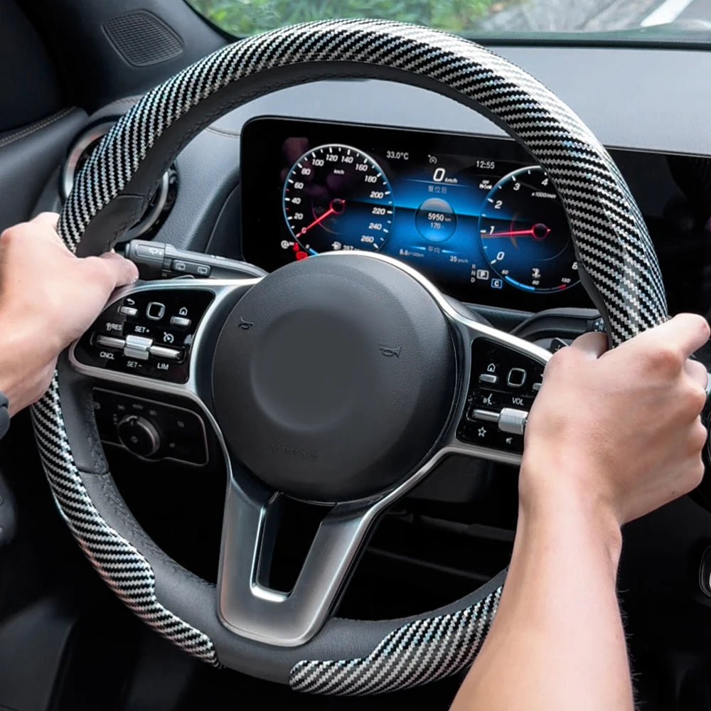 Steering wheel with carbon fiber pattern and dashboard view inside a car